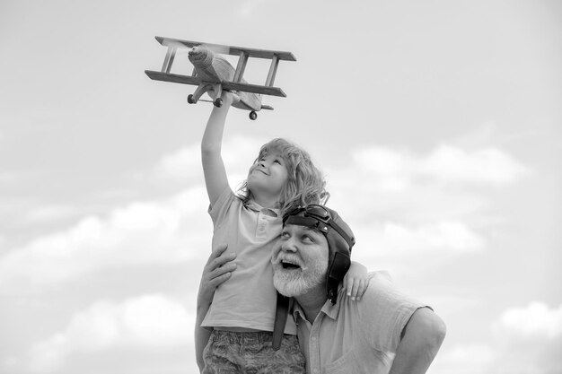 Abuelo e hijo disfrutan jugando con el avión juntos en el cielo azul lindo niño con el abuelo jugando o