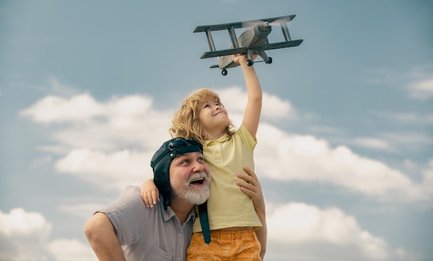 Abuelo e hijo disfrutan jugando con el avión juntos en el cielo azul lindo niño con el abuelo jugando o