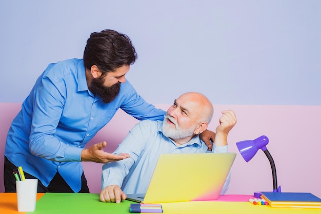 Abuelo e hijo mirando la pantalla de la computadora portátil y leyendo noticias en línea Concepto de familia de hombre feliz usando la computadora portátil juntos Lluvia de ideas juntos en la reunión