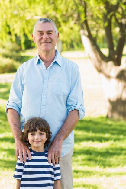 Abuelo e hijo de pie en el parque