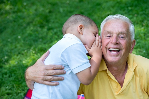 el abuelo feliz y el niño se divierten y juegan en el parque en un hermoso día soleado