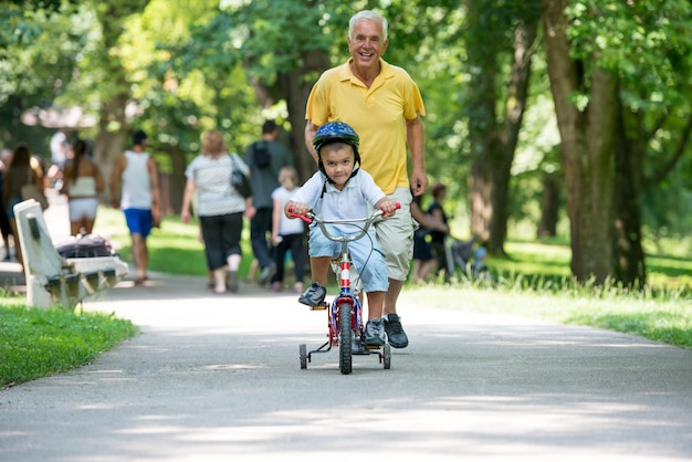 el abuelo feliz y el niño se divierten y juegan en el parque en un hermoso día soleado