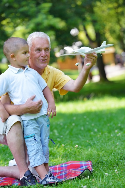 Foto el abuelo feliz y el niño se divierten y juegan en el parque