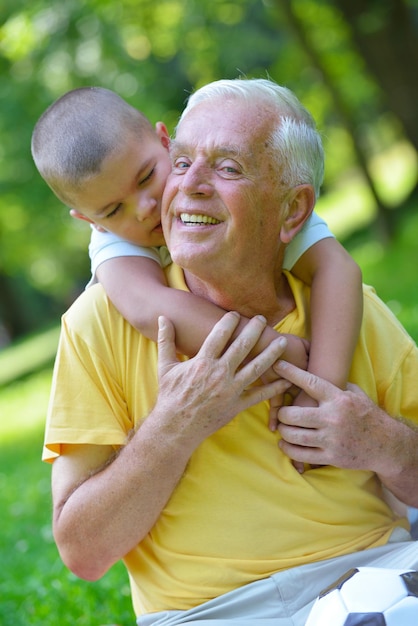 el abuelo feliz y el niño se divierten y juegan en el parque