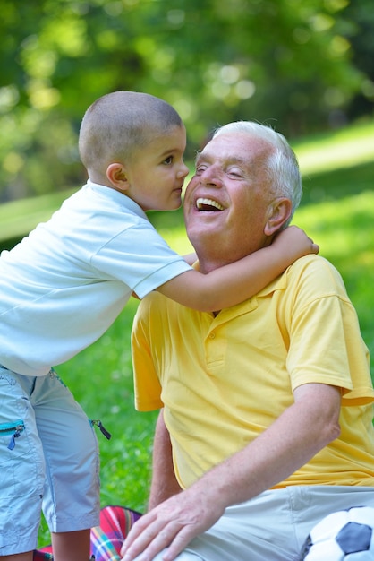 el abuelo feliz y el niño se divierten y juegan en el parque