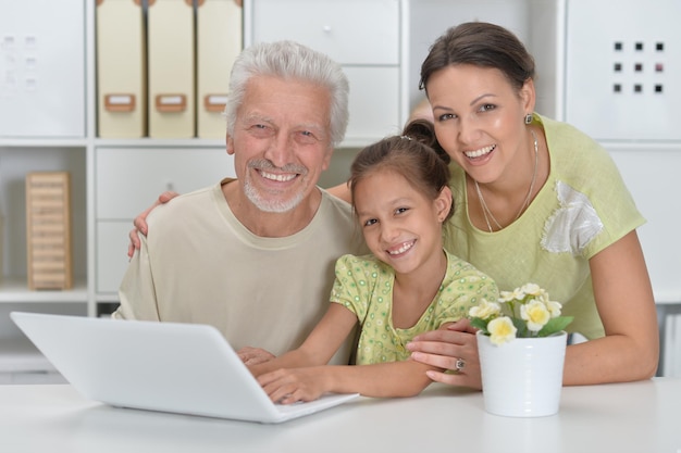 Abuelo, hija y nieta usando laptop