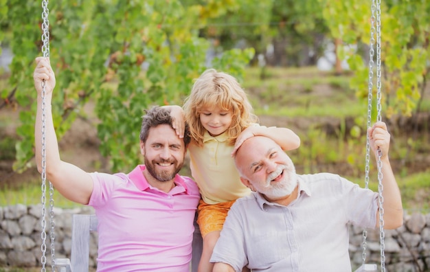 Abuelo con hijo y nieto en un columpio en spring garden al aire libre pring ocio activo para fami