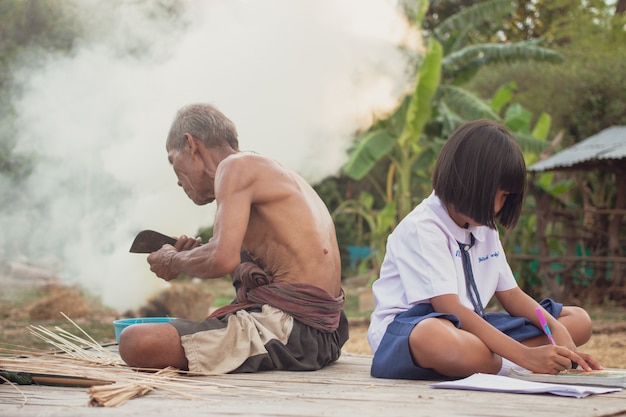 Abuelo y nieta en el campo. Vivir en Asia rural