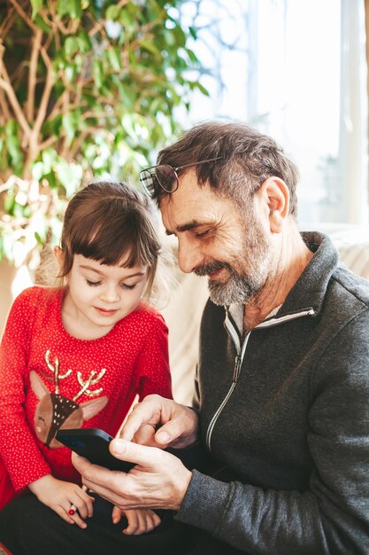 Abuelo y nieta con smartphone