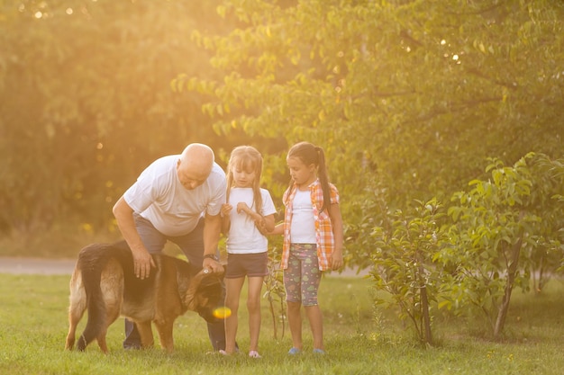 Abuelo y nietas sacando a pasear al perro