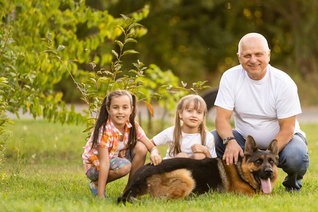 Abuelo y nietas sacando a pasear al perro