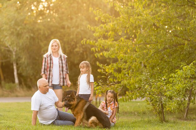 Abuelo y nietas sacando a pasear al perro