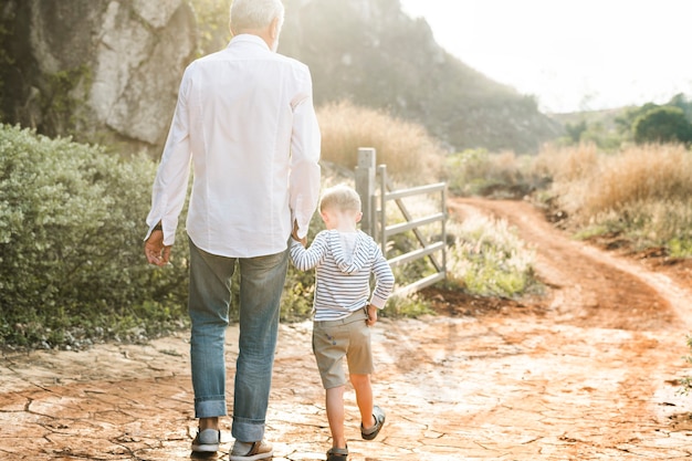 Foto abuelo y nieto caminando en la granja.