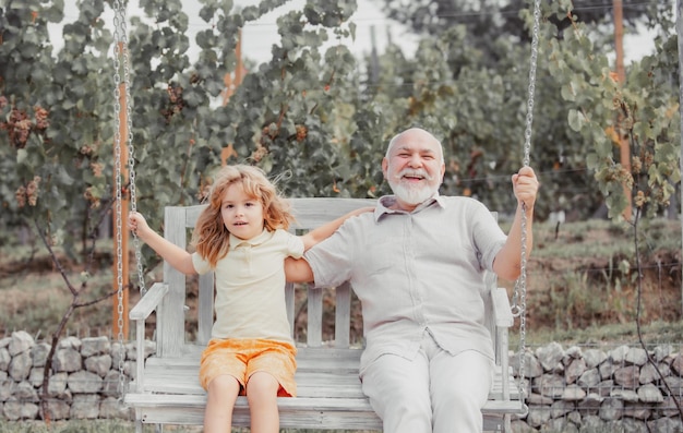 Abuelo y nieto columpiándose en el columpio al aire libre