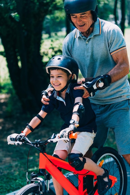 Abuelo y nieto disfrutan del patinaje sobre ruedas y el ciclismo