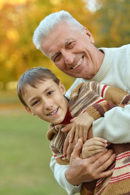 Abuelo y nieto juntos en el parque otoño