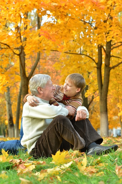 Abuelo y nieto juntos en el parque otoño