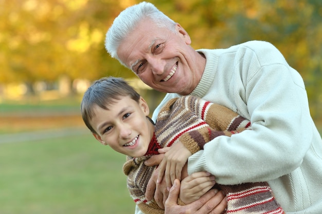 Abuelo y nieto juntos en el parque otoño