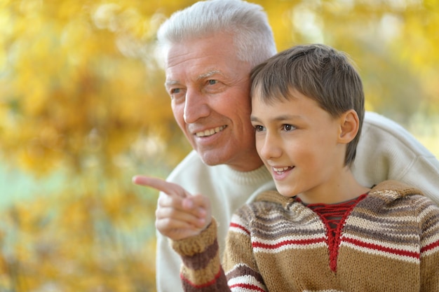 Abuelo y nieto juntos en el parque otoño