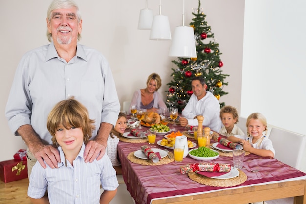 Abuelo y nieto de pie junto a la mesa