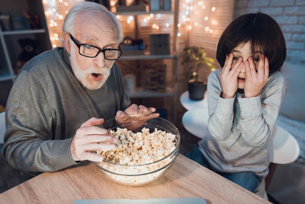 Abuelo y nieto viendo la película de miedo