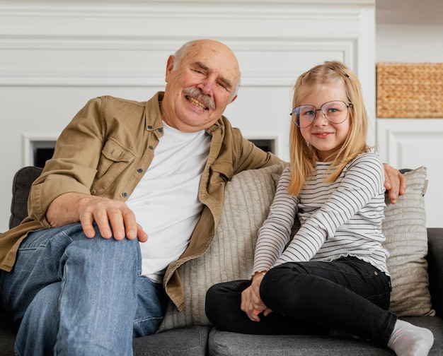 Foto abuelo y niña de tiro medio en sillón