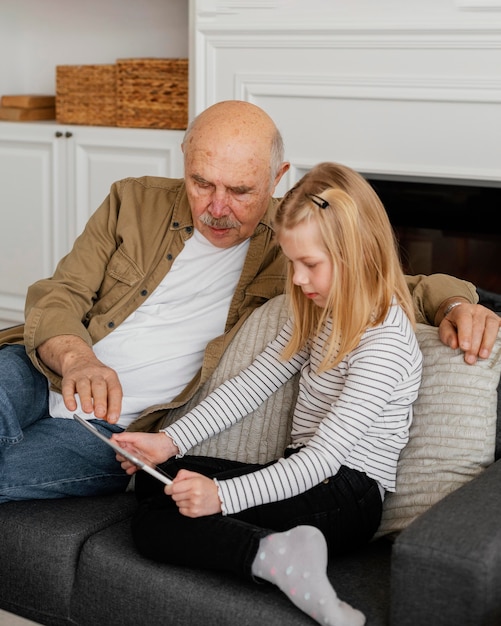 Abuelo y niña de tiro medio con tableta