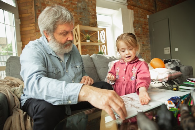 Abuelo y niño jugando juntos en casa concepto de educación de relación familiar felicidad