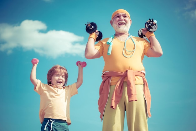 El abuelo y el niño levantando pesas siguen el estilo de vida saludable del abuelo, un niño sonriente y ha.