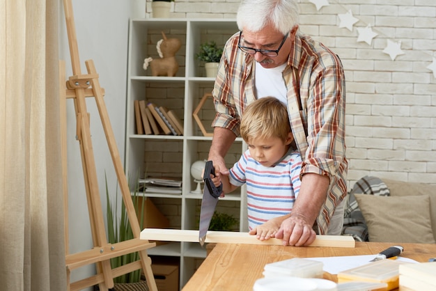 Abuelo y niño trabajando con madera