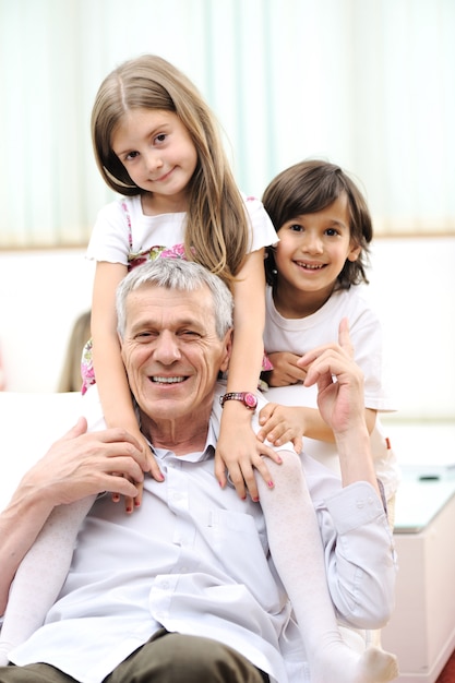 Abuelo con niños, hombre mayor en casa con la familia