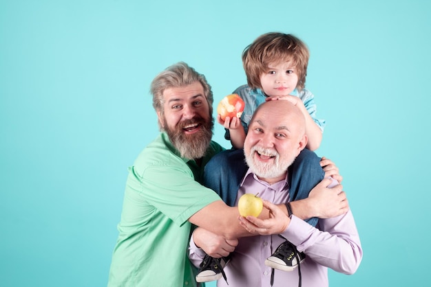 Foto abuelo padre y en abrazar y comer manzana los hombres de diferentes edades con ternura abrazo niño amor cariñoso