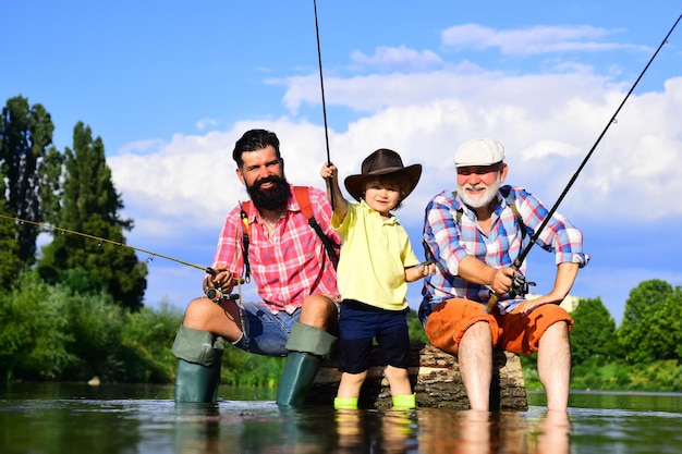 Abuelo, padre e hijo pescan con mosca en el río