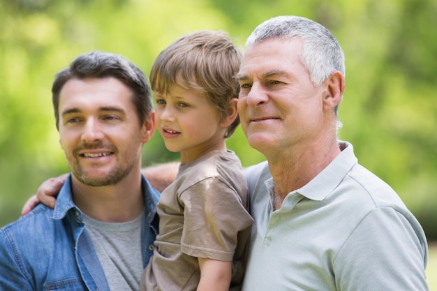 Abuelo padre e hijo sonriendo en el parque