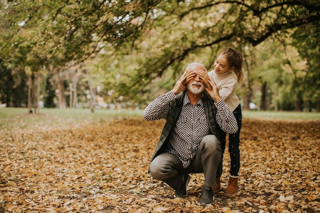 Abuelo pasando tiempo con su nieta en el parque el día de otoño