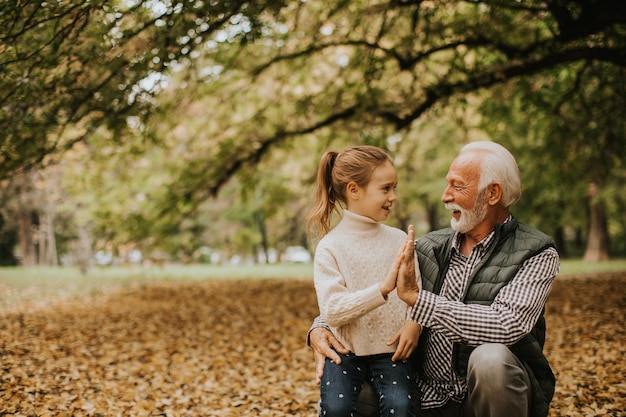 Abuelo pasando tiempo con su nieta en el parque el día de otoño