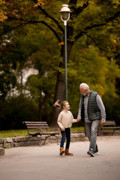 Abuelo pasando tiempo con su nieta en el parque el día de otoño