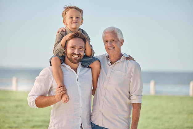 Abuelo y retrato con padre en el parque cargando a un niño o piggy back al aire libre en vacaciones de verano o viaje Amor apoyo y feliz hombre niño y abuelo vinculación cuidado y diversión