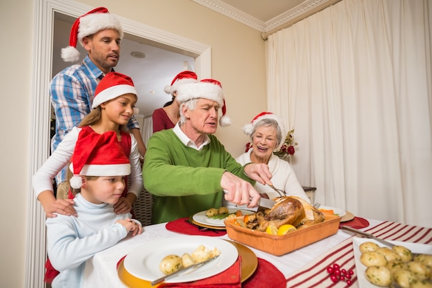 Abuelo en santa sombrero talla de pollo en Navidad