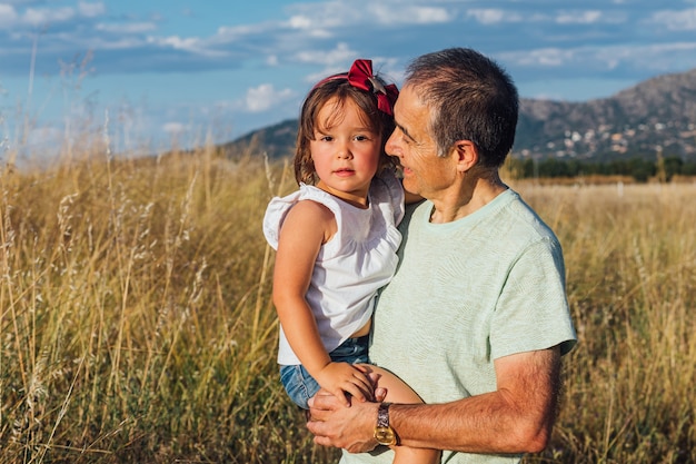 Abuelo con su nieta en brazos al atardecer al atardecer