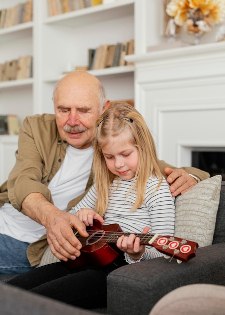 Abuelo de tiro medio y niña con guitarra