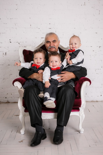 Abuelo con trillizos nietos retrato studio shoot