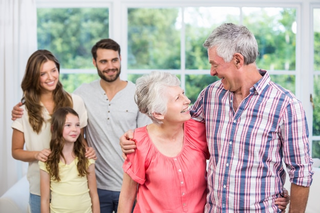 Abuelos abrazados mientras la familia los mira