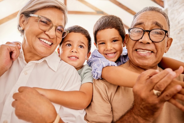 Los abuelos se abrazan y los niños juntos en una casa con felicidad, amor familiar y cuidado de niños Retrato de ancianos felices con niños sonriendo y pasando tiempo de calidad en una casa familiar