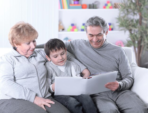 Abuelos amorosos con nieto sentado en el sofá