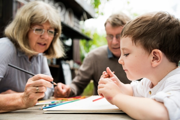 Abuelos ayudando a niño con libro para colorear