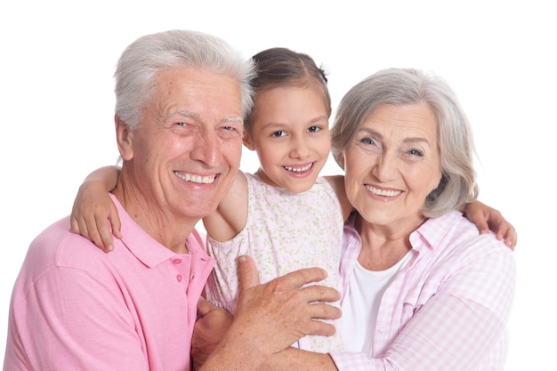 Abuelos felices con nieta sobre fondo blanco.