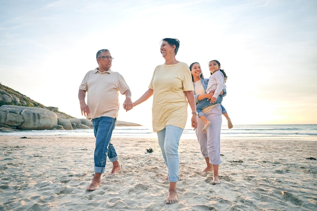 Abuelos madre e hijo generaciones y tomados de la mano en la playa viajes y vacaciones tropicales Gente al aire libre hombre con mujeres y niñas aventuras y sonrisas en la naturaleza con confianza