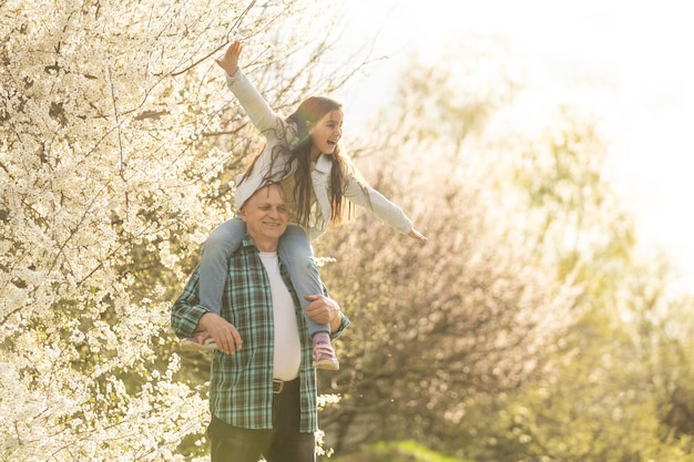 Abuelos mayores con nieto en huerto en primavera.