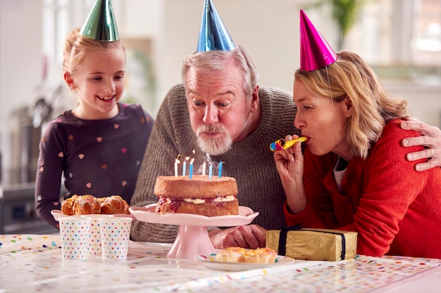 Abuelos con nieta celebrando cumpleaños con fiesta en casa juntos